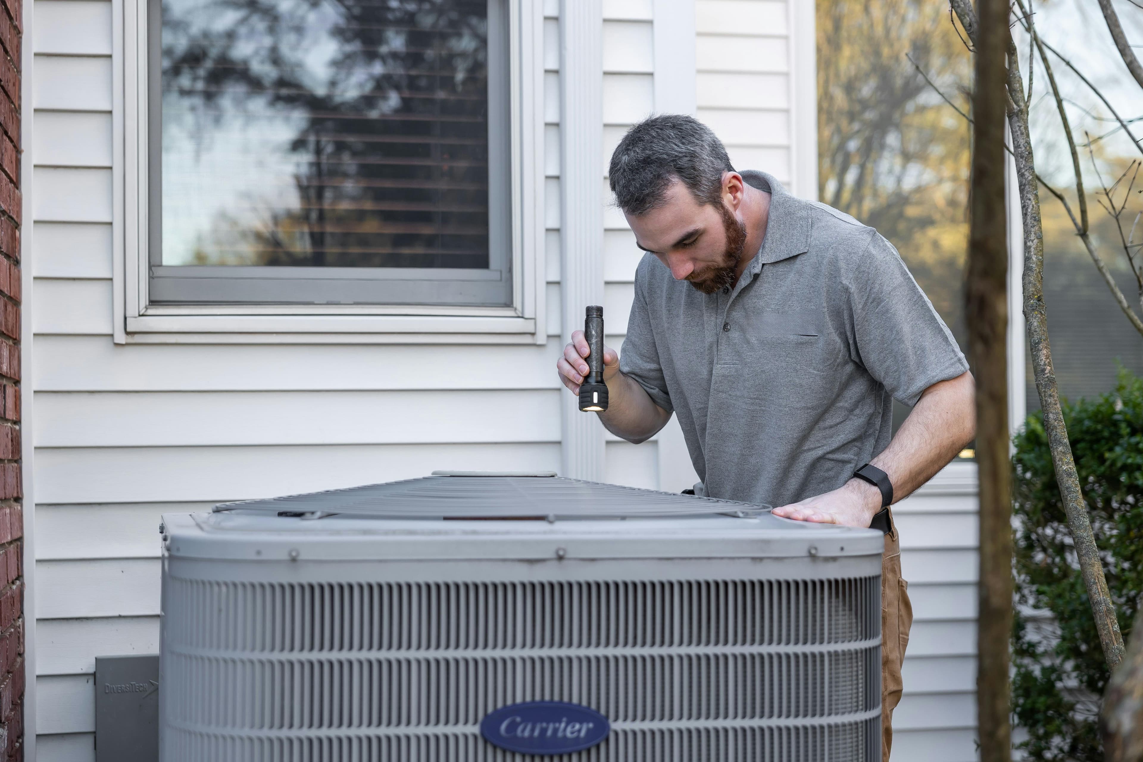 HVAC technician servicing an air conditioning unit